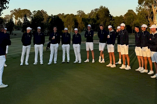 Golf team gathered on the green during a meeting.