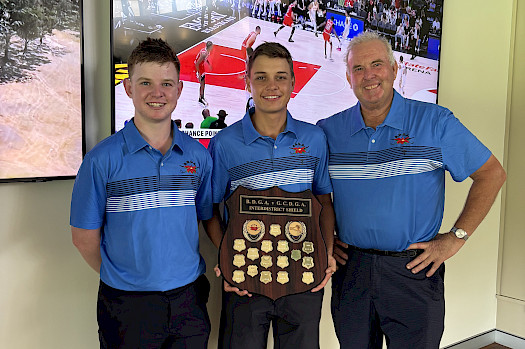 Three men in matching blue shirts holding a golf plaque award.
